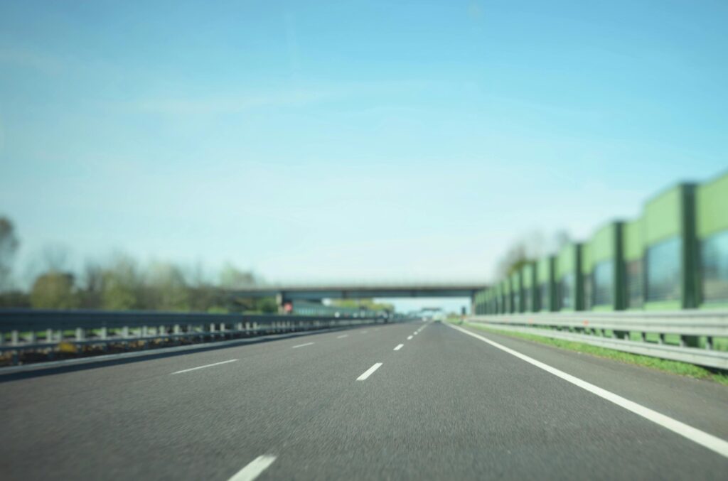 A straight highway stretches into the distance under a clear blue sky, ideal for travel concepts.