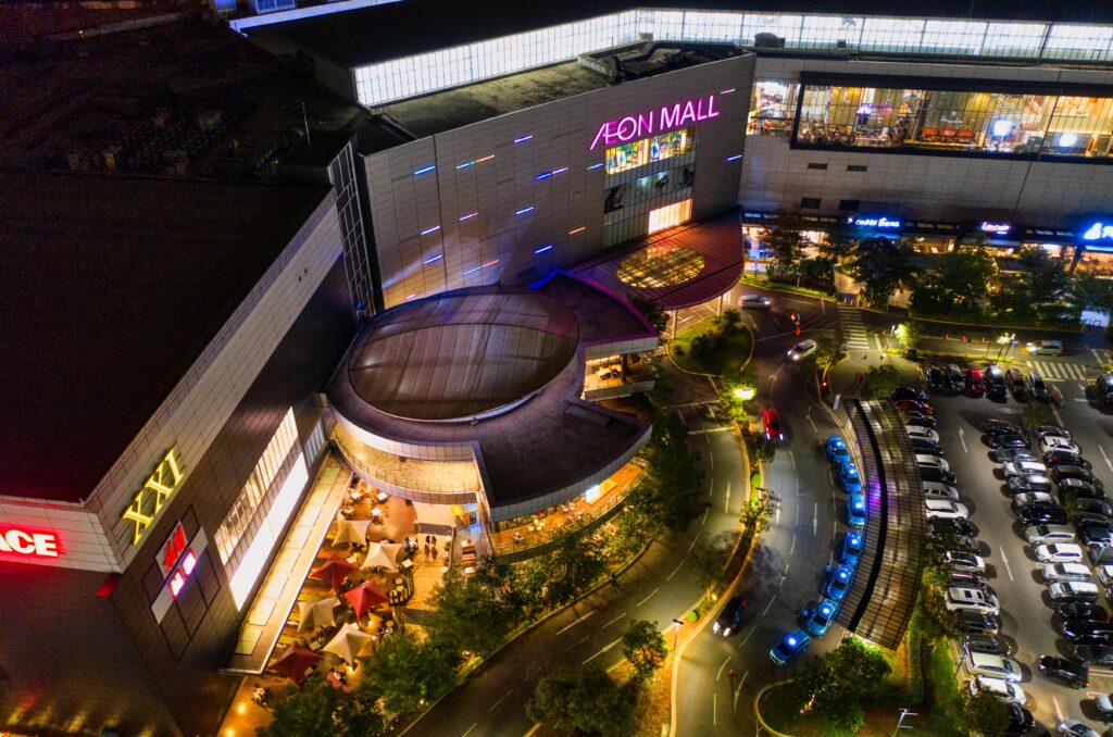 Illuminated aerial view of Aeon Mall in Banten, Indonesia, featuring a bustling parking lot at night.